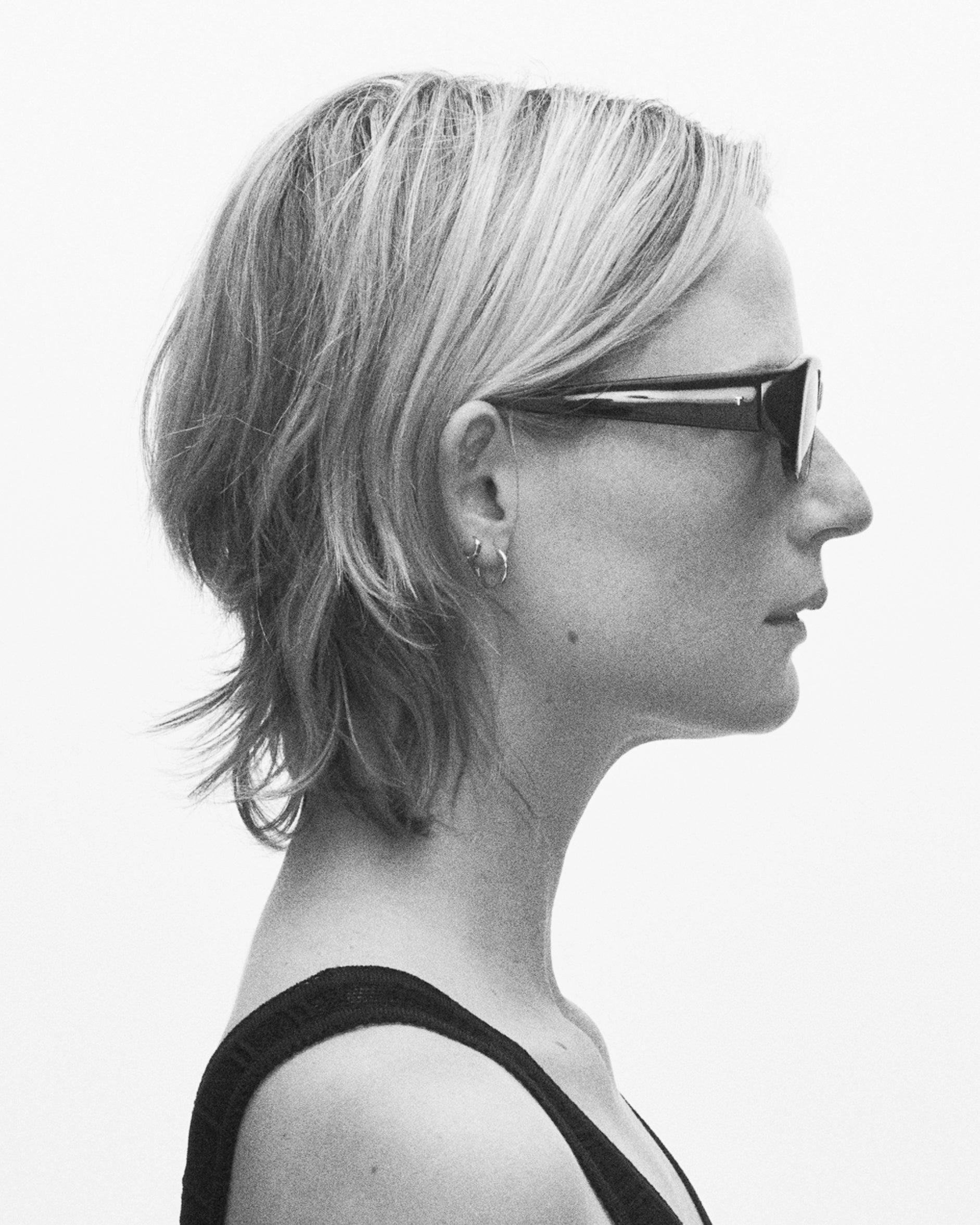 model wearing sunglasses, facing rightward