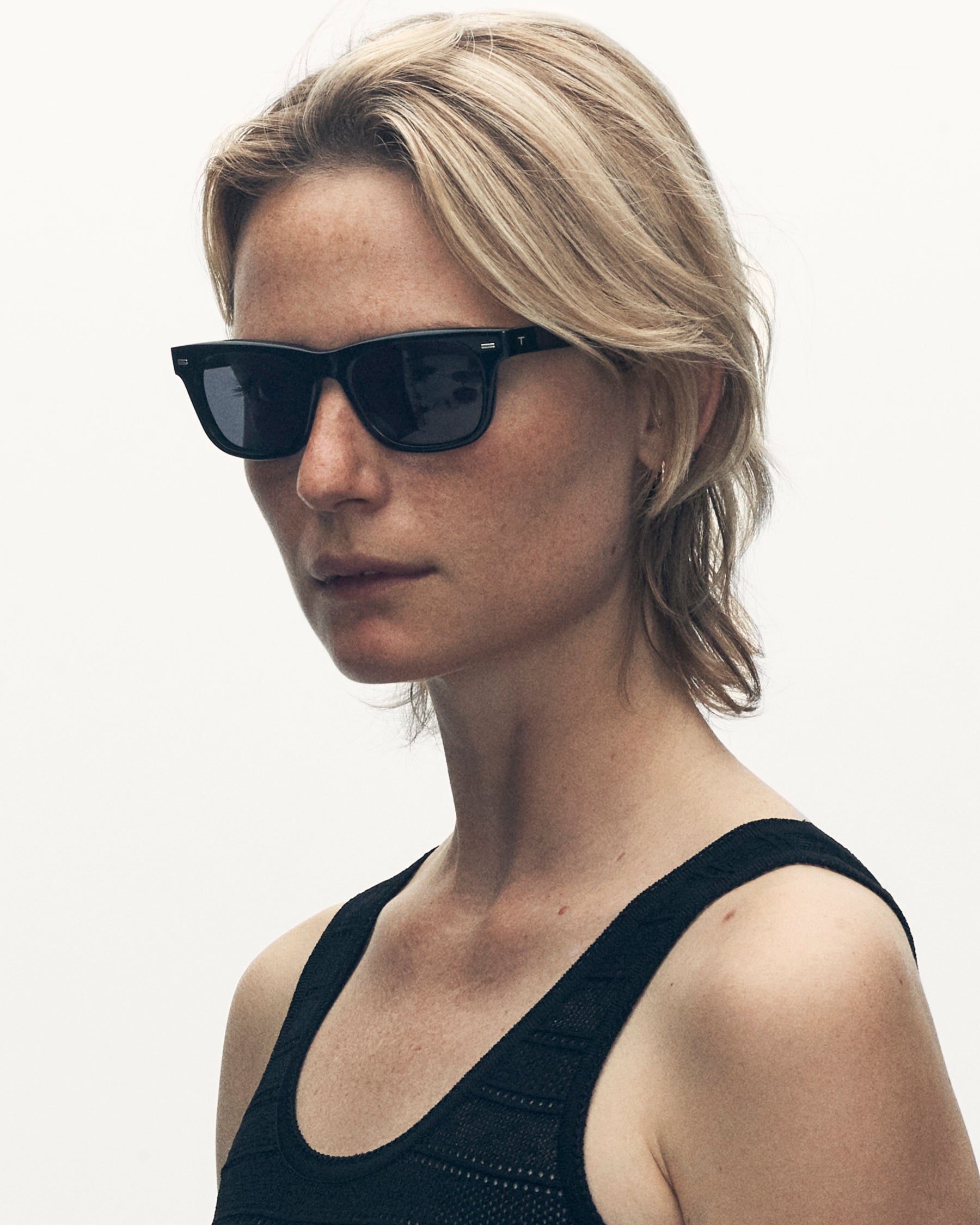 model wearing sunglasses. she is looking just beyond the camera.