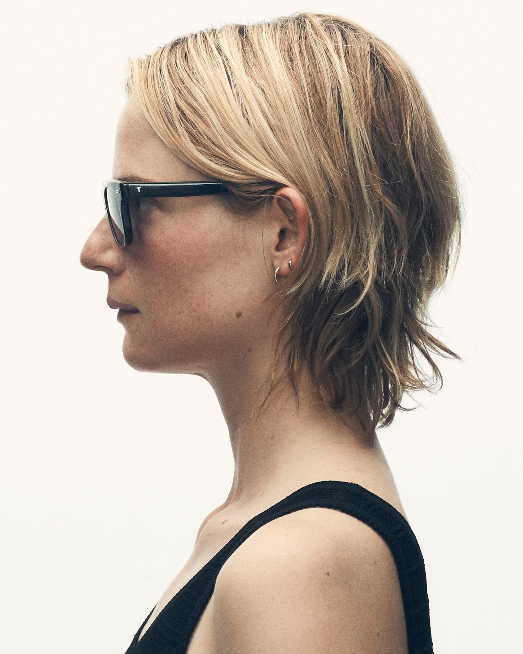 model wearing sunglasses, facing leftward