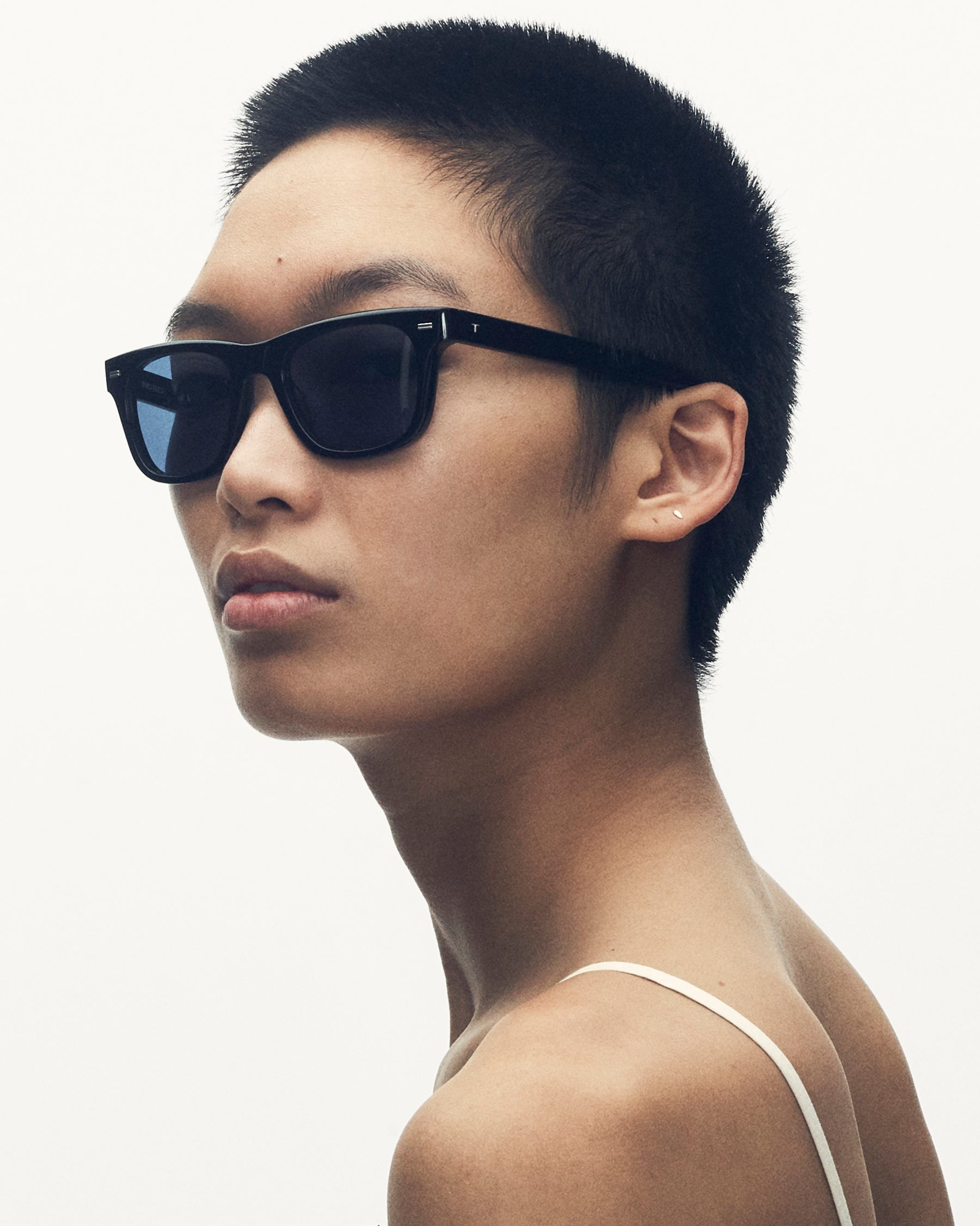 model wearing sunglasses. she is looking over her shoulder at the camera.