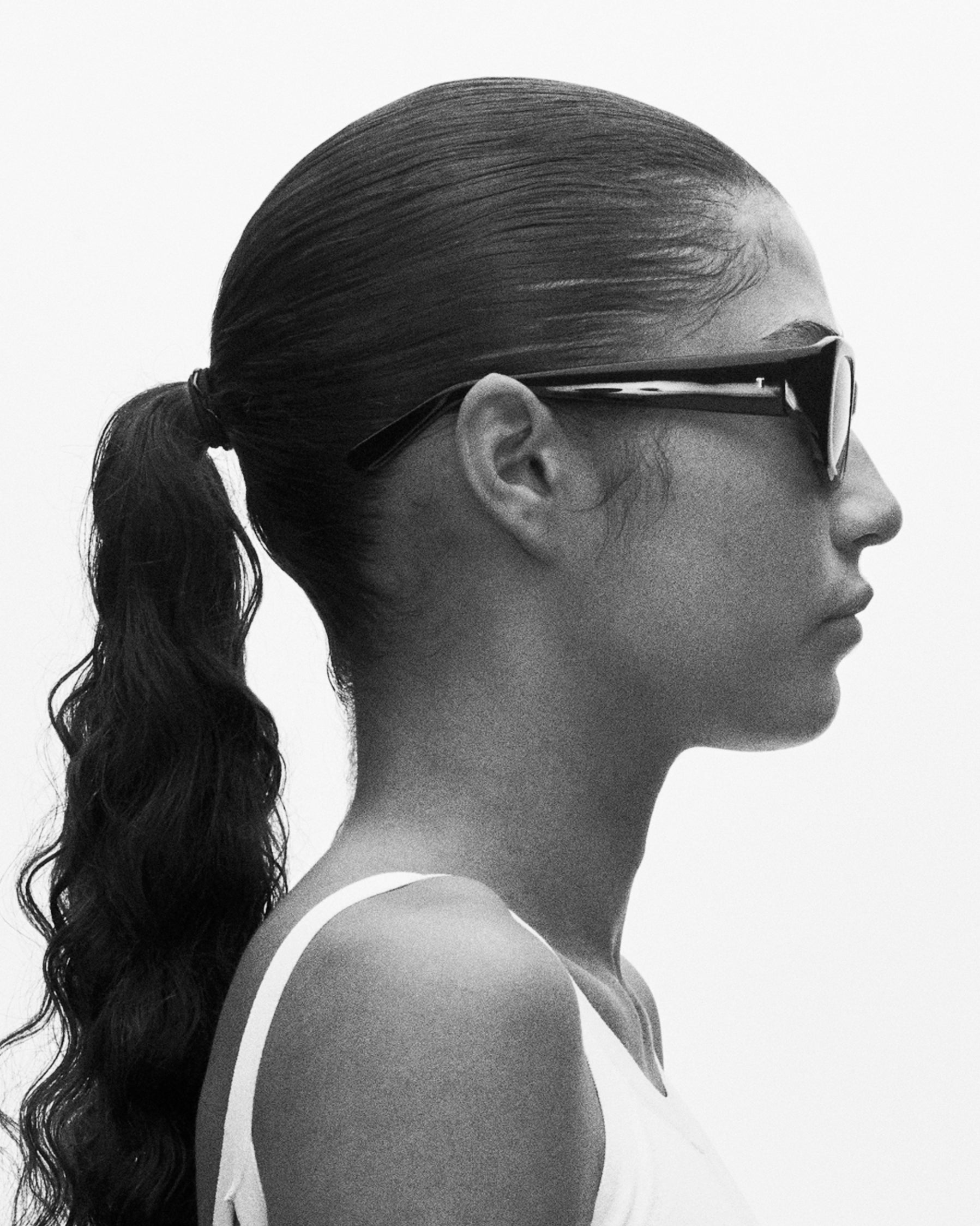 model wearing sunglasses, facing rightward
