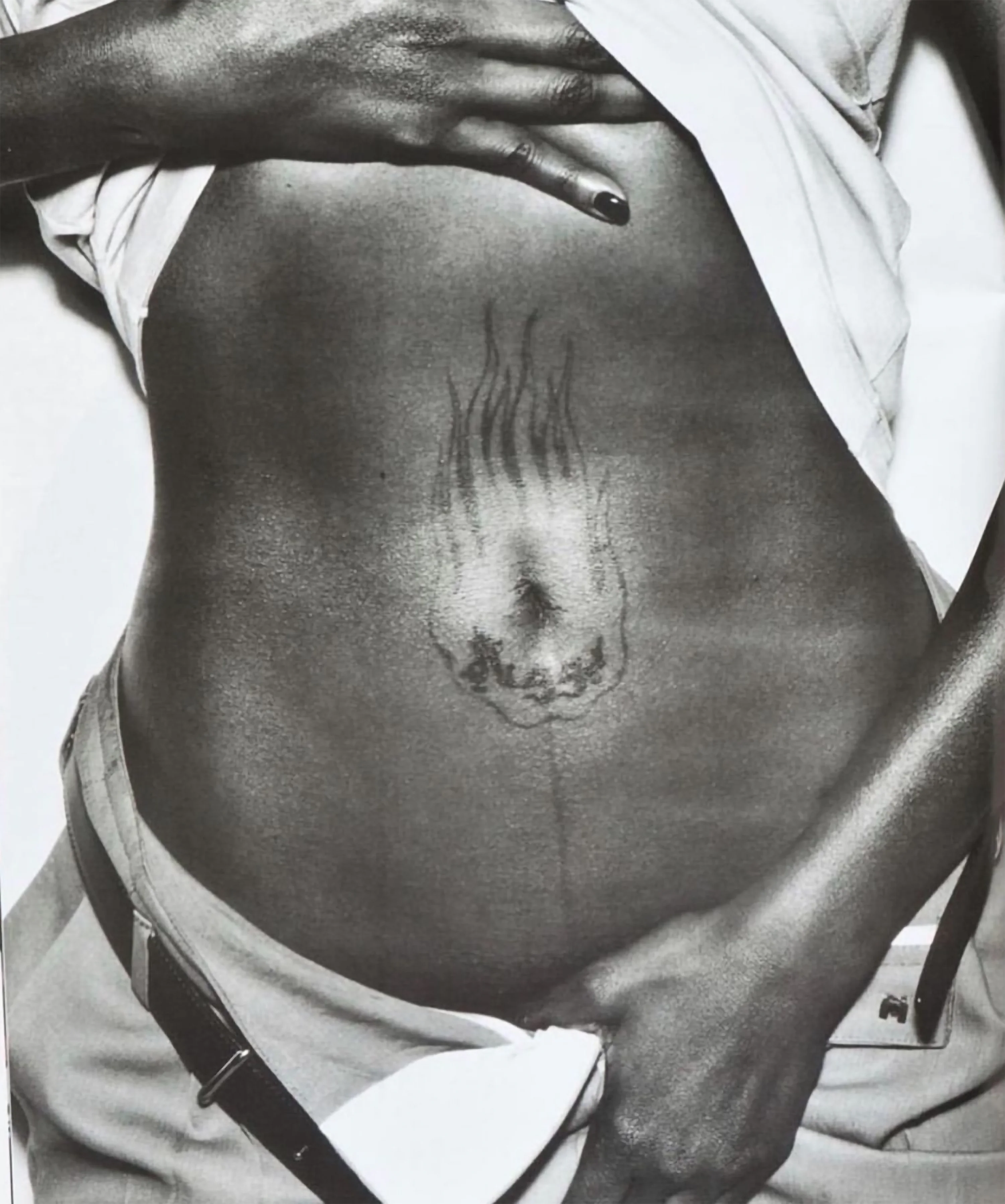 a belly button tattoo depicting a flame