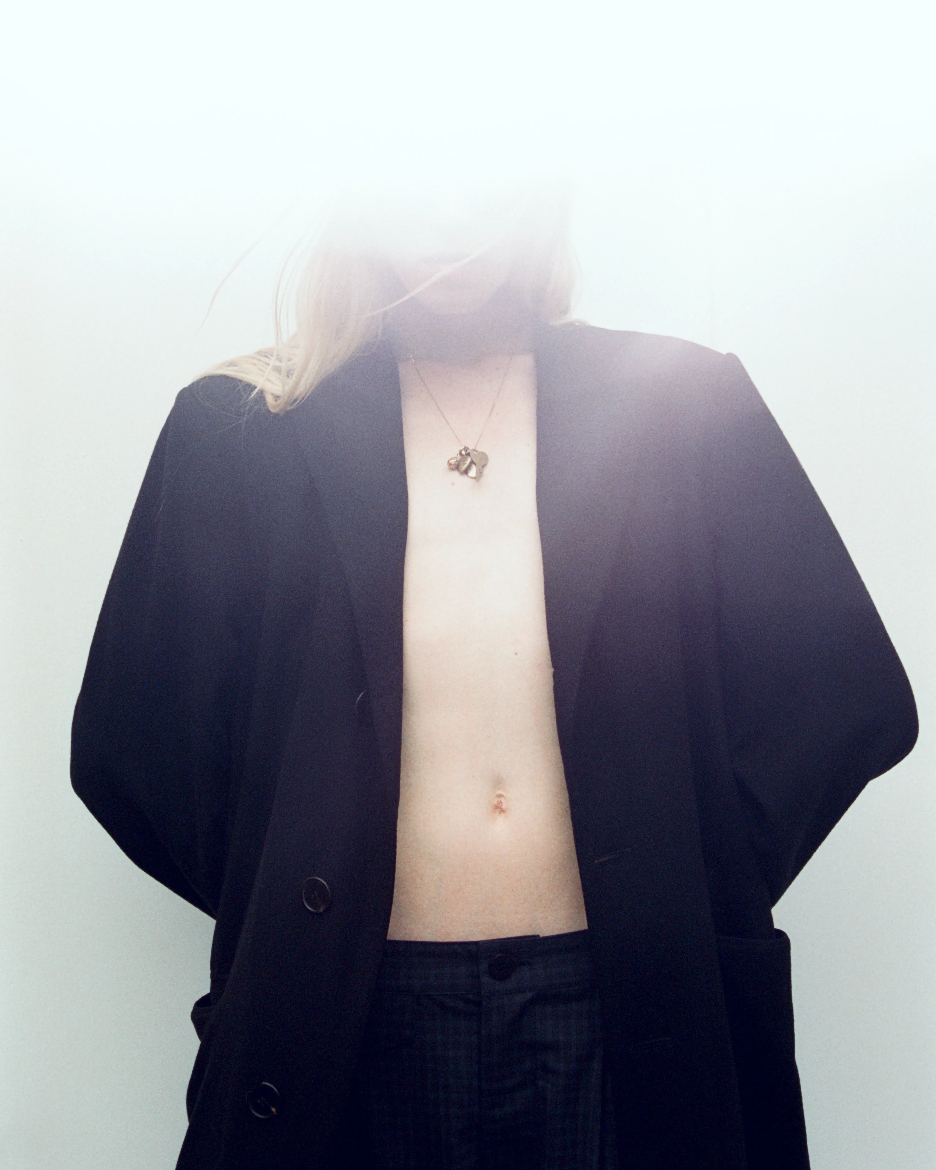 person leaning against a wall where the camera glare is obstructing their head