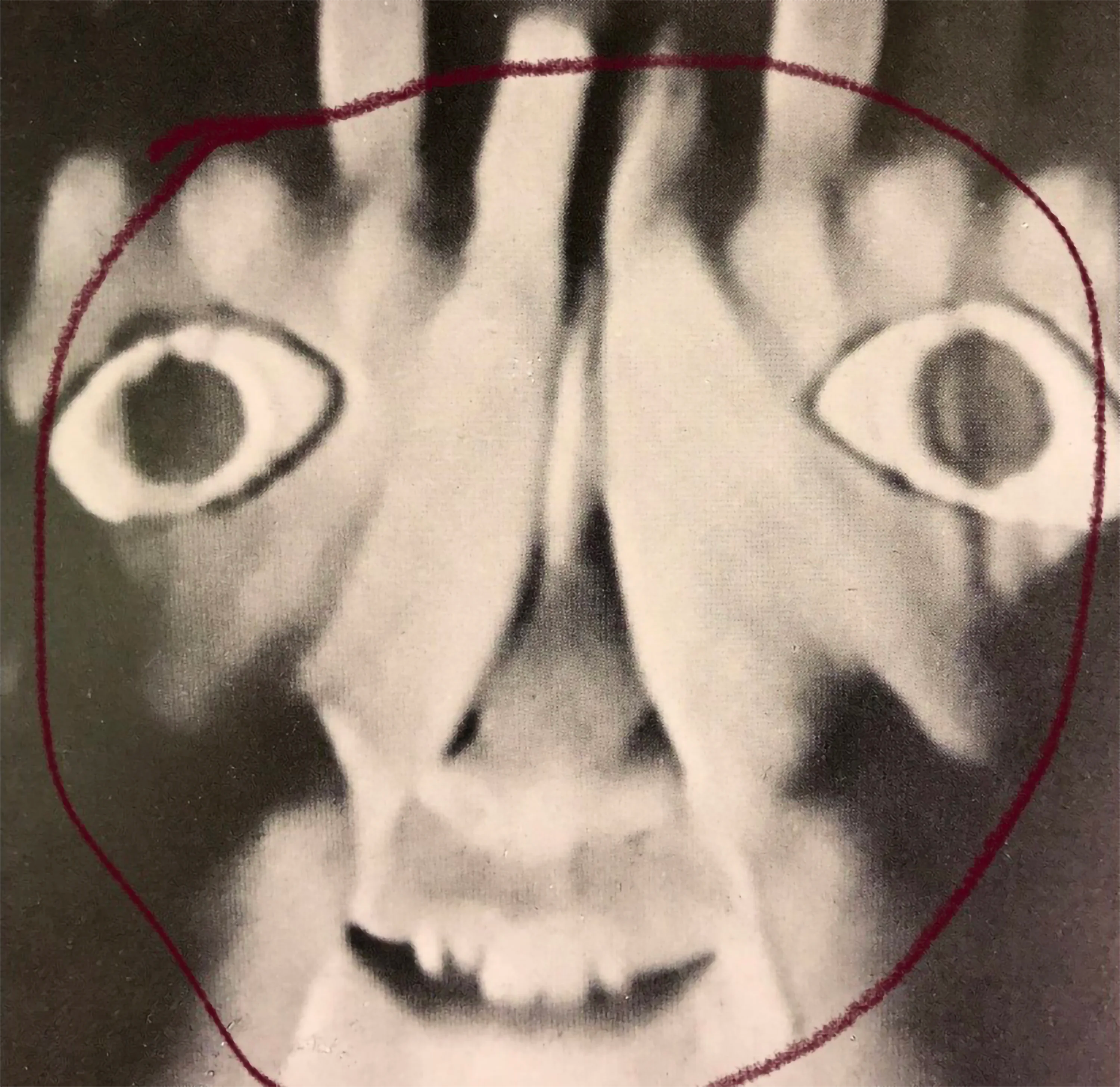 a person covering their face with two hands. there are eyes painted onto the backs of their hands.